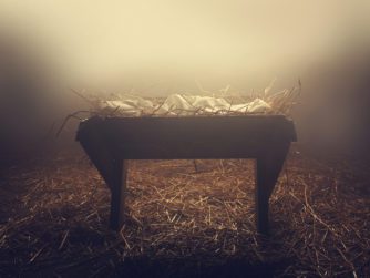 An empty manger at night under the fog.