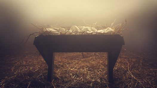 An empty manger at night under the fog.